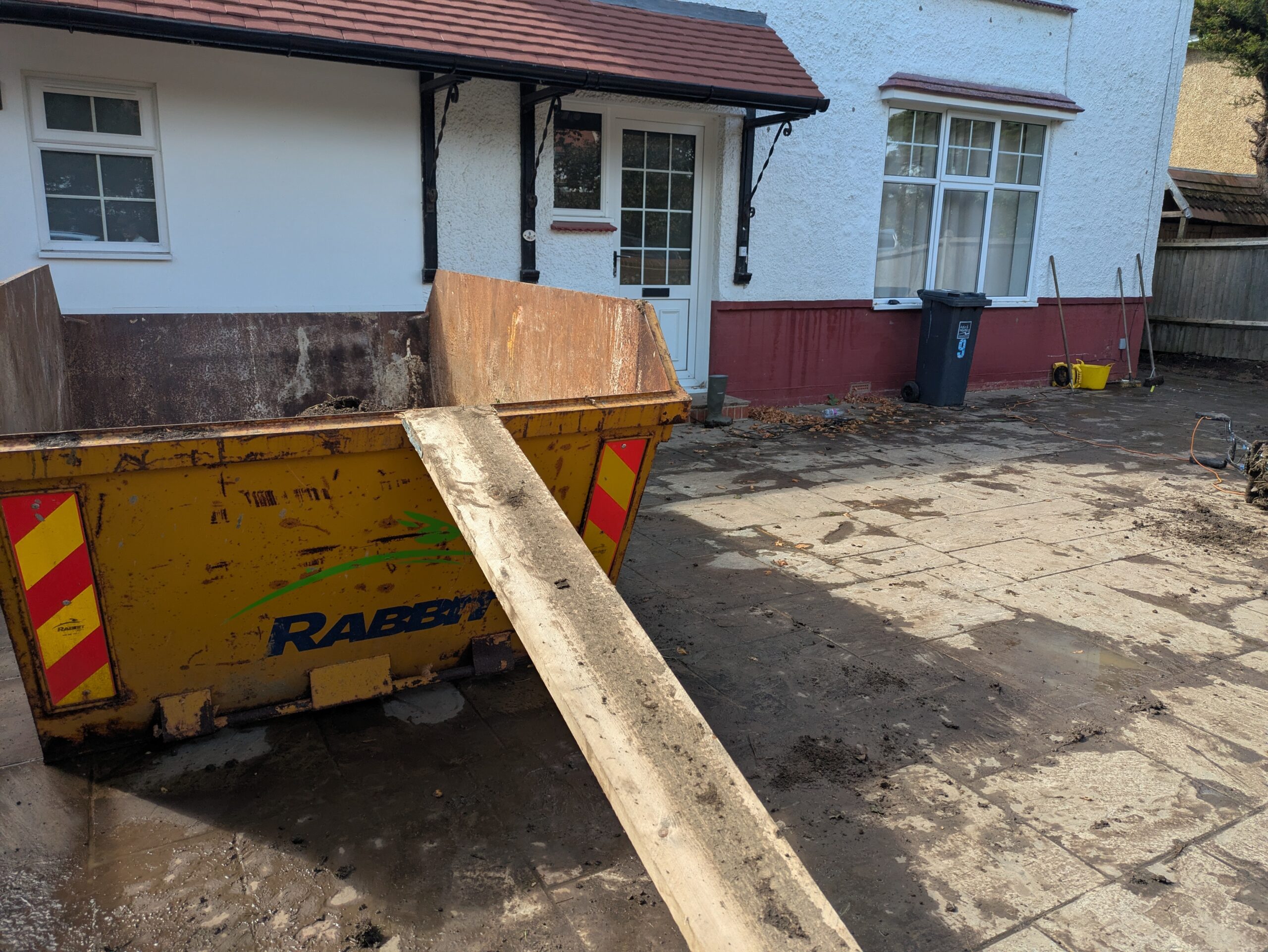 picture of a skip on a driveway of a landscaping job completed by handymanhelp.uk in Worthing
