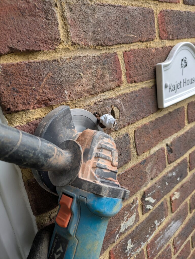 Angle grinding off a rusted masonry bolt on this wooden porch repair job