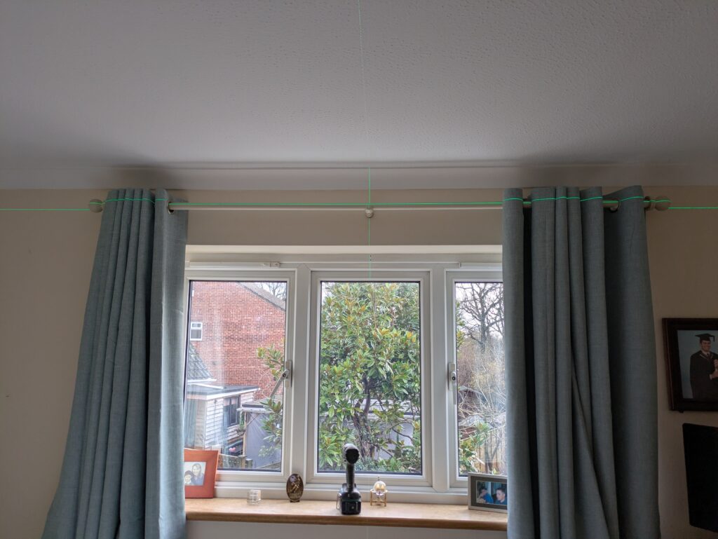 Hanging a curtain rail in Worthing, checking the level of the newly fitted curtain rail in Worthing